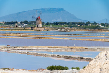 Sea saltworks, salt wind mills and pans, manually extracting high-quality salt, near Marsala and...