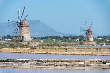 Sea saltworks, salt wind mills and pans, manually extracting high-quality salt, near Marsala and...