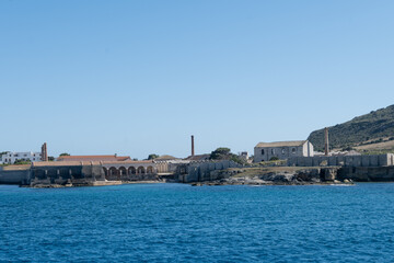 Boat trip and view on coastline of Favignana island with small village, shallow bays with clear...