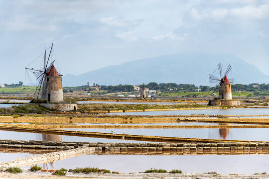 Sea saltworks, salt wind mills and pans, manually extracting high-quality salt, near Marsala and Trapani, Sicily, Italy
