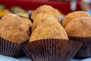 Arancini Sicilian, deep-fried rice balls made with risotto, filled with ingredients mozzarella, ragu, peas, coated in breadcrumbs fried to crispy, brown on market in Palermo, Sicily