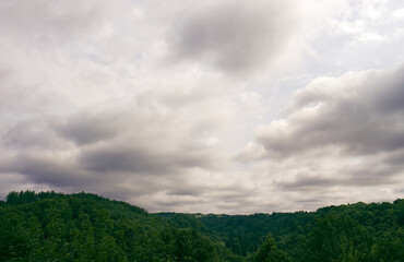 Dramatic storm clouds over forest-covered hills. Nature of the Czech Republic. Changeable weather. Dark storm clouds
