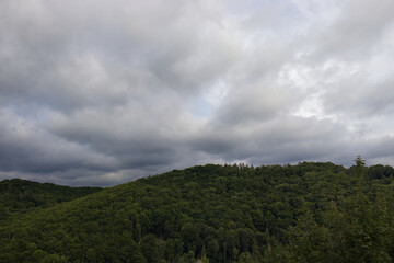Dramatic storm clouds over forest-covered hills. Nature of the Czech Republic. Changeable weather. Dark storm clouds