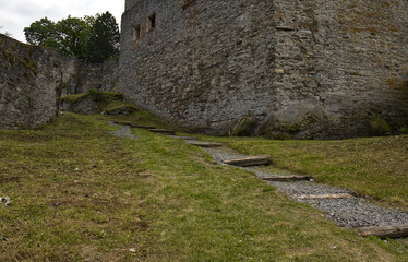 Open castle courtyard.Courtyard of a stone castle with a stone walkway and grass.Gentle stairs in the outdoor open part of the castle complex.Ruins of castle buildings. Monuments of the Czech Republic