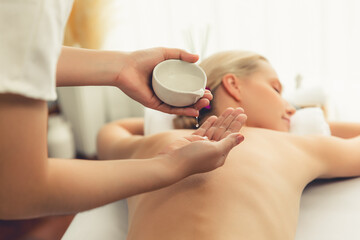 Masseur hands pouring aroma oil on woman back. Masseuse prepare oil massage procedure for customer...