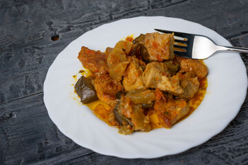 Savory Eggplant and Tomato Stew with Tender Chicken Pieces on a Rustic Plate
