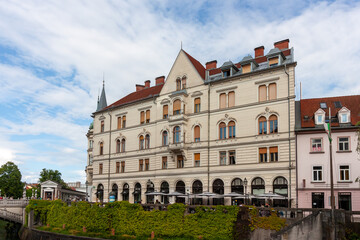 A grand, elegant building with classic European architecture stands prominently in Ljubljana,...