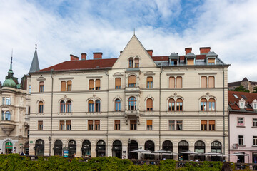 A grand, elegant building with classic European architecture stands prominently in Ljubljana,...