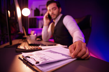 Smart businessman calling partner or investor on smartphone, discussing on target market database...