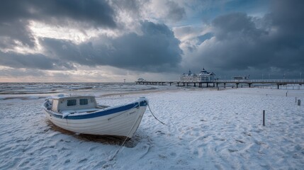 Naklejka premium Serene Winter Scene: White Fishing Boat on Snow-Covered Beach with Seabridge and Dramatic Clouds in Usedom, Germany