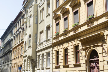 Rows of classic european residential buildings with intricate architectural details, windows, and decorative elements, lining a city street in a historic district, and historical architecture.