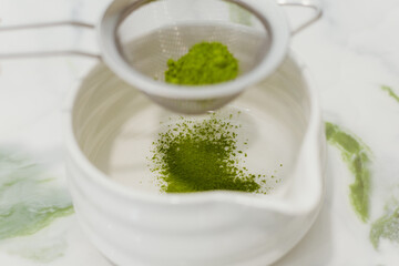 Matcha latte, making a matcha latte with ice, milk, bamboo whisk green tea. 
