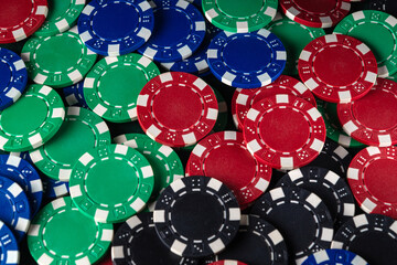 Various poker chips of different colors laid out on the table create a bright atmosphere for a...