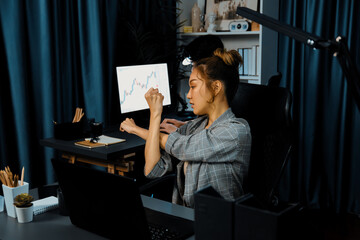 Businesswoman working on desk with stretching arm up and down manner with body health ache of...