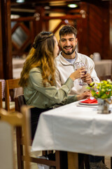 Young Couple Enjoying Red Wine and Delicious Food on Date