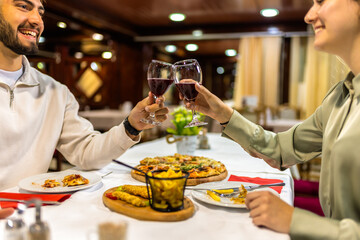 Young Couple Toasting with Red Wine Before Dinner