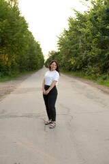 Young attractive woman standing on rural road	