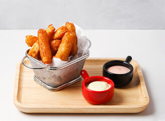 Crispy Salt and Pepper Squid Strips in metal frying basket with Wasabi and Mentaiko Mayo Dips on...