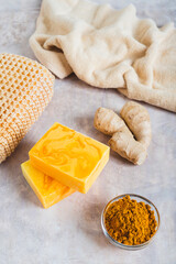 Herbal turmeric soap bars and root on the table vertical view