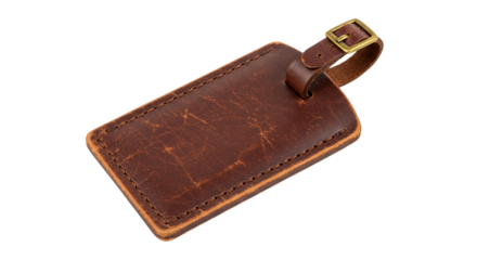 A close up shot of a brown leather luggage tag with a brass buckle on a black background