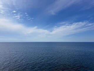 Open sea blue calm waters and blue sky white clouds.