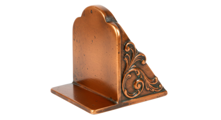 Close up of a single copper bookend with ornate floral design against a black background studio shot