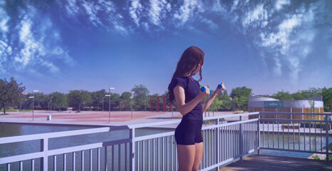 Fitness model exercising with dumbbells on a bridge in a city park, promoting healthy lifestyle