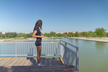 Young woman performs stretching exercises with resistance bands in a park setting