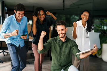 Group of young multi-ethnic startup business team collaborating on project in modern office