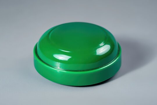 Large green game show buzzer on gray background cordless button for kid education or anim