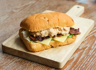 Gourmet Bacon Focaccia Sandwich with Cheese, Lettuce, and Savory Sauce on wooden board side view of fast food menus