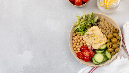 Colorful Buddha bowl with quinoa, hummus, chickpeas, vegetables. Healthy dish. Copy space