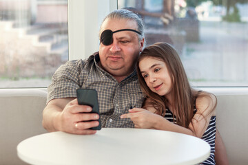 Father and daughter bonding while using a smartphone in a causal indoor setting