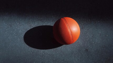 Close-up of a basketball on a black surface. the basketball is in focus, while the background is blurred, making it the focal point of the image.