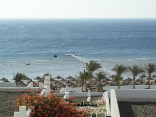 A man on a pontoon and a red flag on the sea