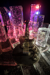 Music Concept: Guitar Miniature on a Dark Background with Vivid Light, Smoke, and Fire Effects....