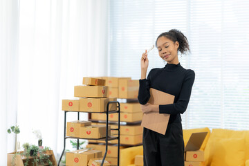 Online Business Owner: A young, confident woman smiles thoughtfully, holding a clipboard amidst...