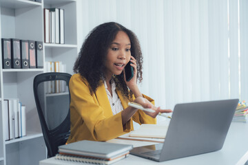 Confident Communication: A vibrant business woman in a yellow blazer engages in a professional...