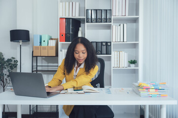 Business Professional at Work: An engaging shot of a businesswoman diligently working at her desk,...
