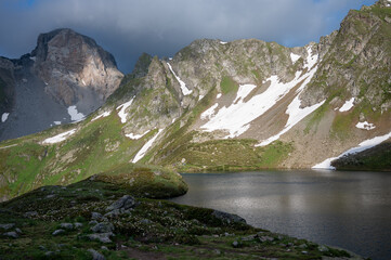 mountain landscape with lake and mountains in the clouds