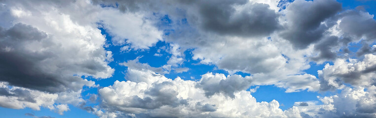 Dramatic cloudy sky with cumulus and stratocumulus clouds on a bright summer day. 
