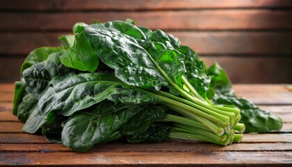 close up shot of freshly harvested leafy green vegetables such as spinach or kale arranged on a rustic wooden tabletop