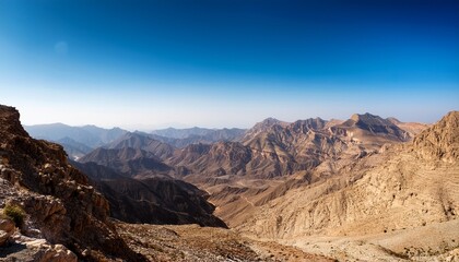 explore the stunning mountainous landscapes of oman under a clear blue sky during midday
