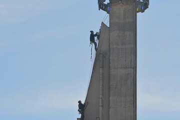 Craftsmen repair the tower of a modern church. Roofers fix the tower of a modern building. The concept of working at heights and work safety