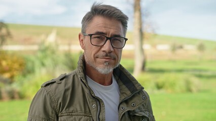 Portrait of confident middle aged man wearing glasses outdoor. Farmer, landowner standing on ranch...