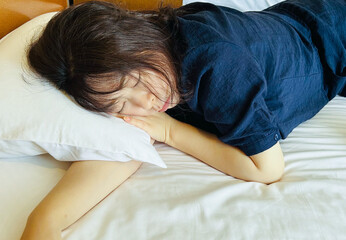 ベッドの上で昼寝をしている女性