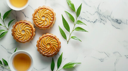 Traditional Chinese delicacy, mooncake sweet with cup of green tea on marble white table decorated with green branches, tea ceremony, layout, top view, copy space for cafe and pastry shop
