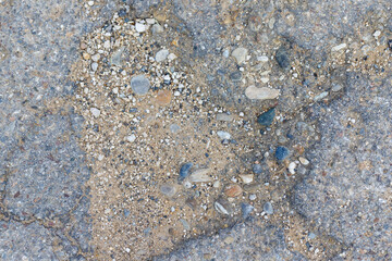 Damaged Asphalt with Exposed Gravel and Sand