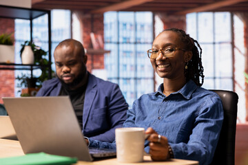 African american man and woman sit at the desk discussing freelance strategies, researching...