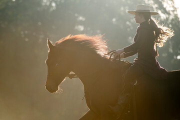 Cowgirl exercising her horse early in the morning